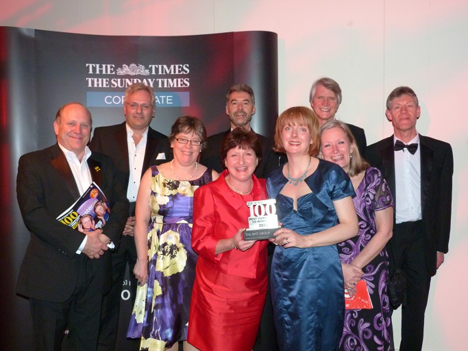 BMT Staff holding Sunday Times Top 100 Award Trophy
